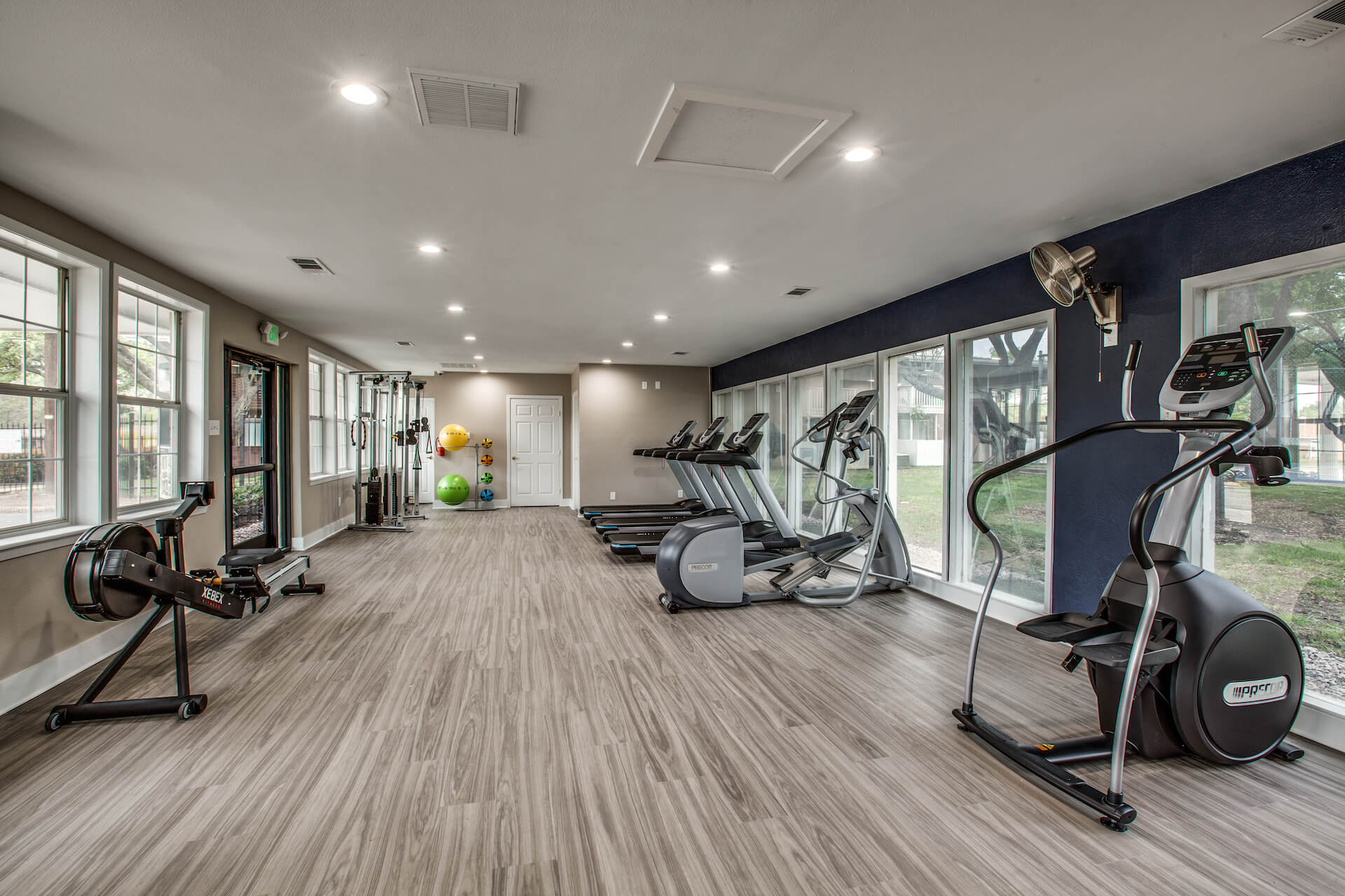 upgraded fitness center with wood-style flooring, medicine balls and mirrors